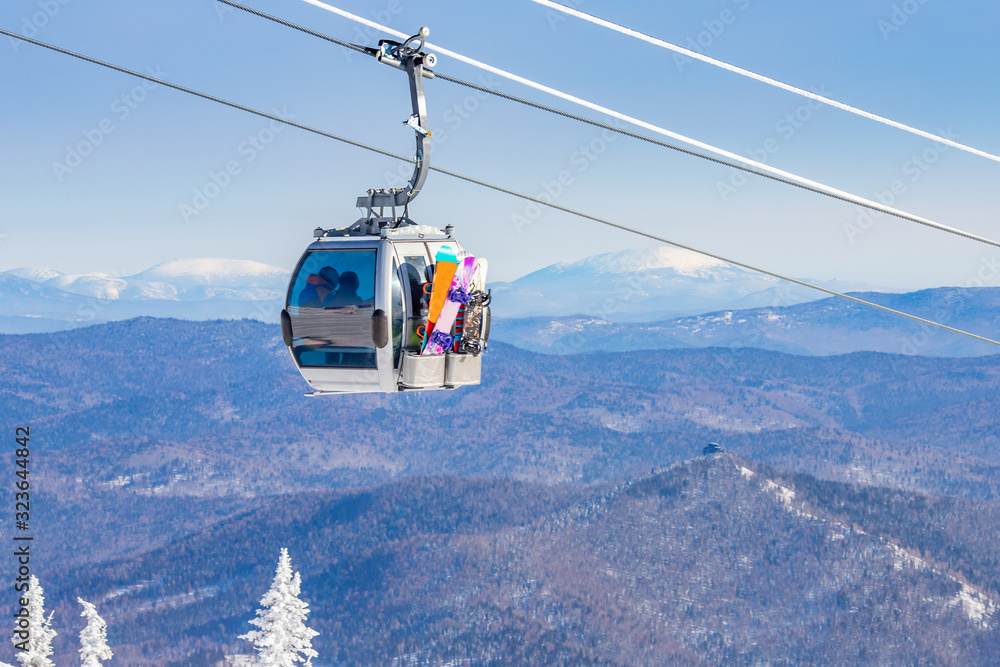 Cabin lift for ski resort on background of mountains and blue sky, sunny day Cabin lift for ski resort on background of mountains and blue sky, sunny day