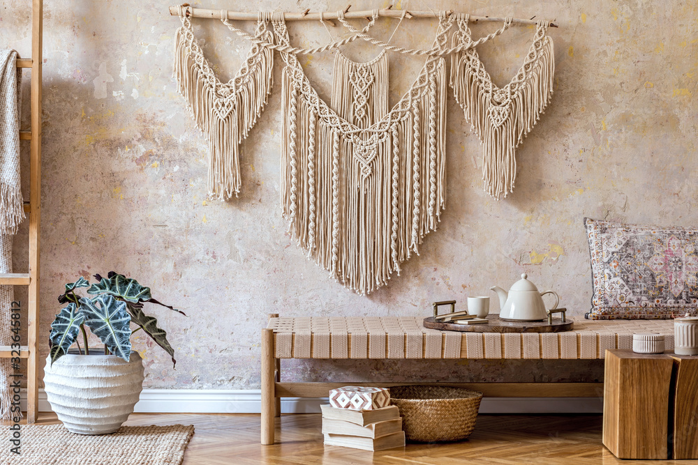 Obraz premium Interior design of stylish living room with beige chaise longue, beautiful macrame, wooden cube, ladder, plants, tea pot on the tray and elegant personal accessories. Oriental concept of home decor.
