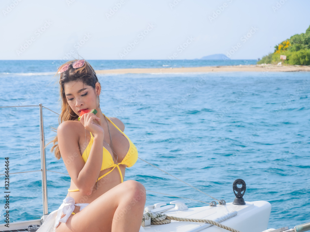 Sexy asia woman wearing yellow bikini  on yacth with blue sky blue sea background in Pattaya Thailand