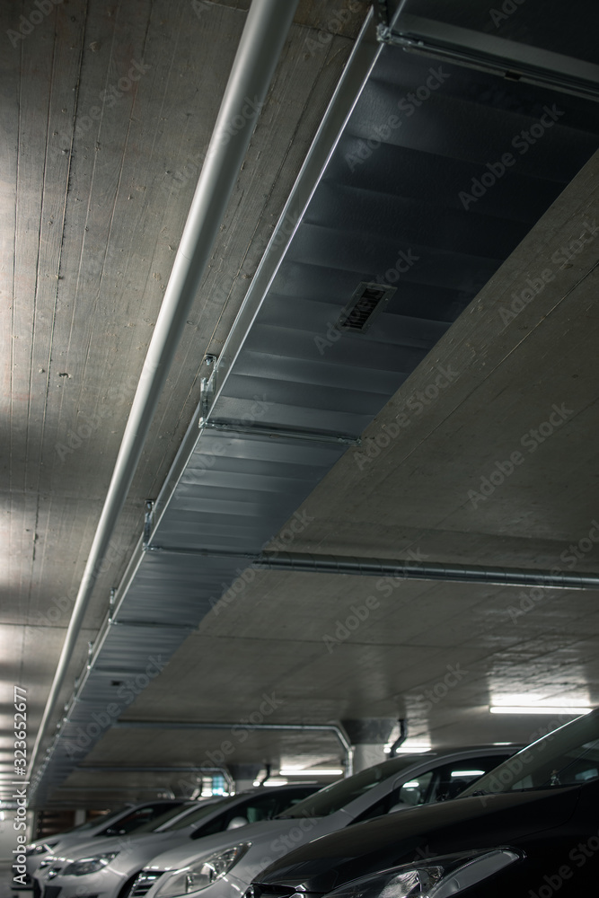 Underground parking. Cars parked in a garage with no people. Many cars in parking garage interior. Underground parking with cars (color toned image) Underground parking. Cars parked in a garage with no people. Many cars in parking garage interior. Underground parking with cars (color toned image)