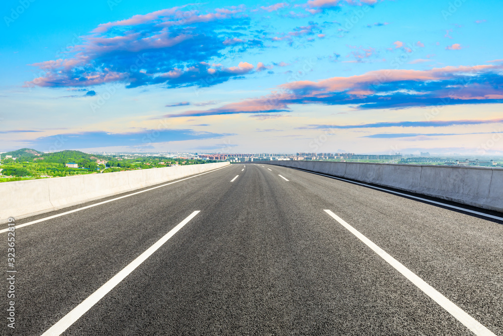 Fototapeta premium Empty asphalt highway and city suburb skyline in Shanghai at sunset.