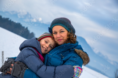 Caring mother hugging her daughter in the snow