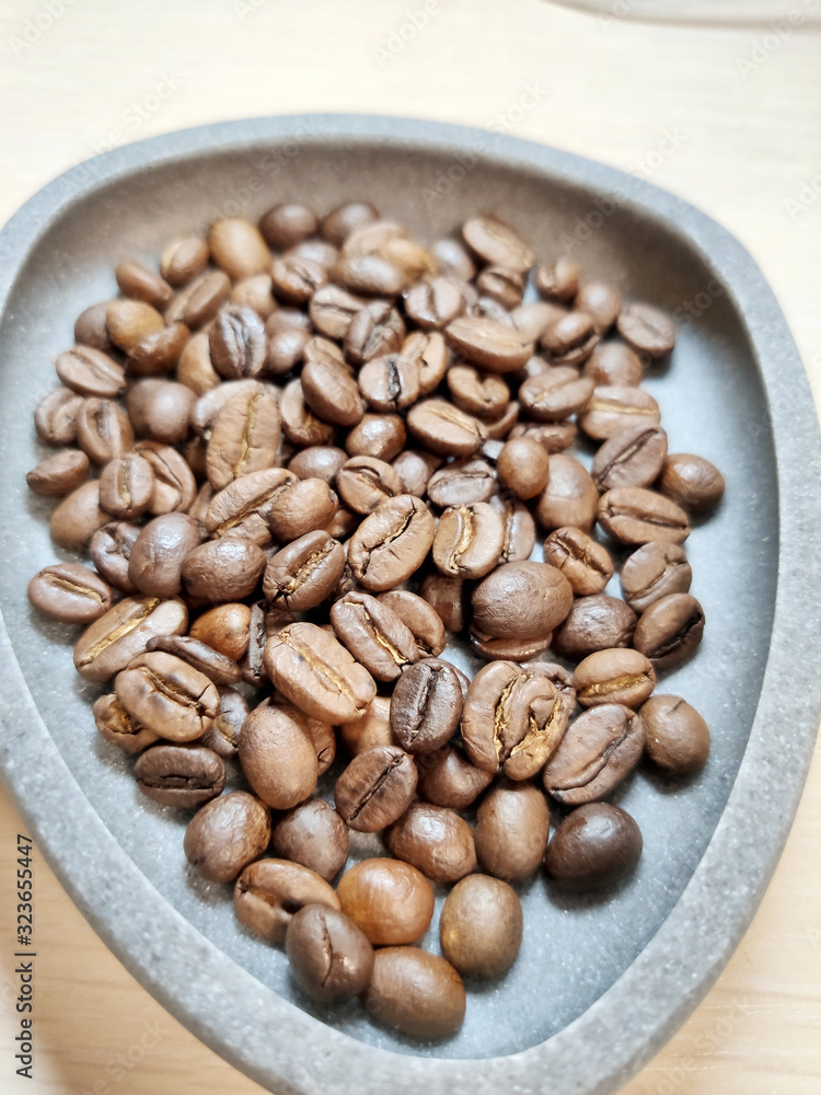 Fototapeta premium Coffee beans in a gray bowl on a white background.
