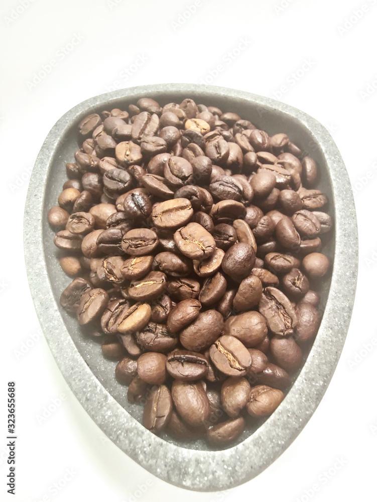 Coffee beans in a gray bowl on a white background. Coffee beans in a gray bowl on a white background.