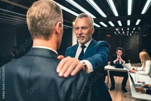 The businessmen handshaking each other