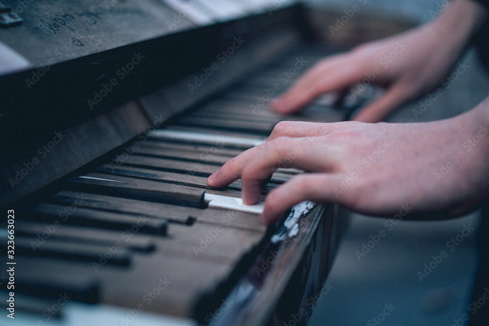 Fototapeta premium A man plays the old vintage piano. close-up. film noise emulation.
