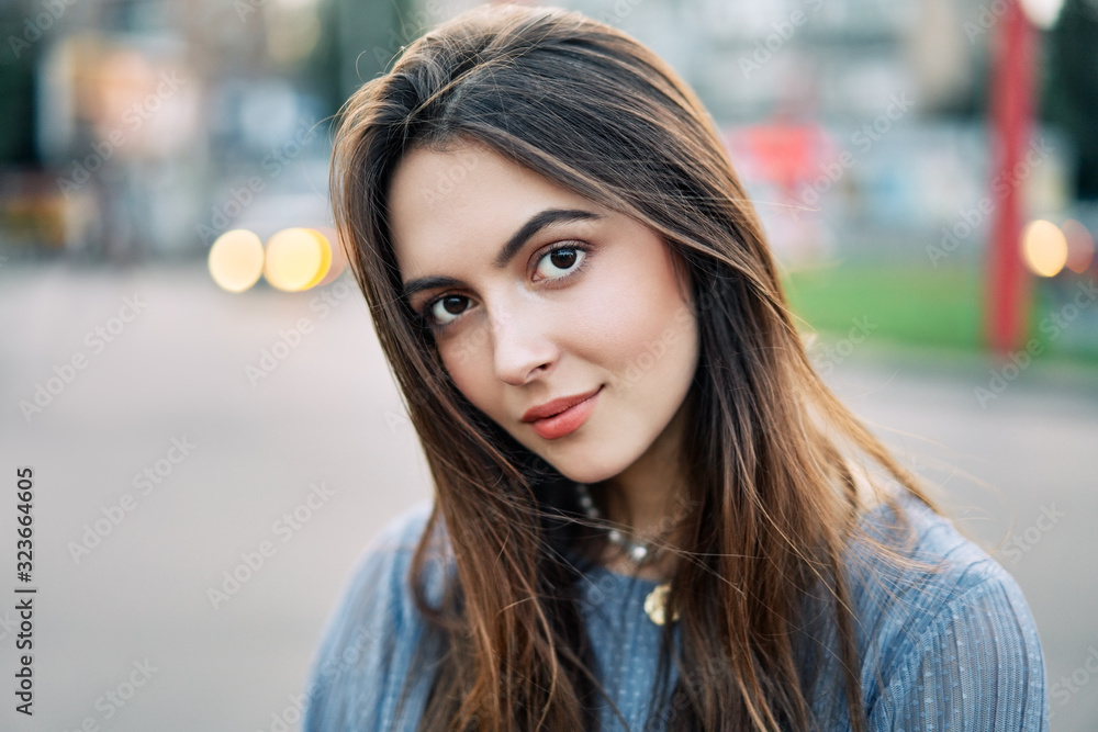 Close up young beautiful woman portrait posing in the city street Close up young beautiful woman portrait posing in the city street