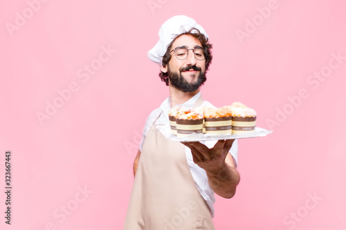 Tela young crazy baker man confectionery concept against pink wall