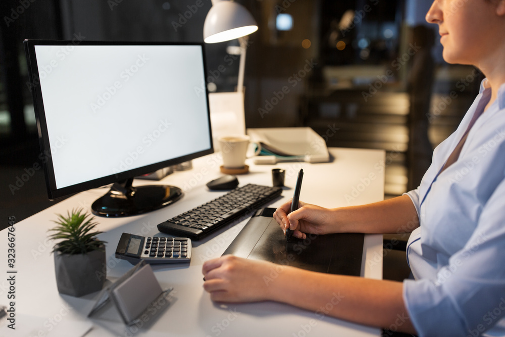 business, design and technology concept - creative woman or graphic designer with computer and pen tablet working at night office business, design and technology concept - creative woman or graphic designer with computer and pen tablet working at night office
