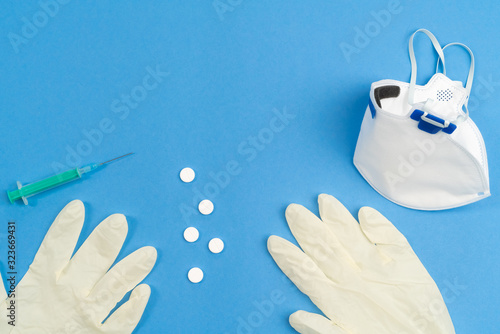 Still life of medical objects - flu vaccine, pills and needle on blue background. Corona virus, covid-19 treatment