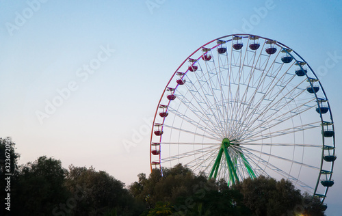 Colorful ferris wheel in the city park at evening.