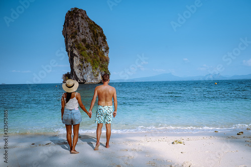 couple on the beach, Koh Poda Thailand, The beautiful landscape of Koh Poda or Poda Island in Krabi province of Thailand. This island has white sand beach and surrounded by crystal clear water