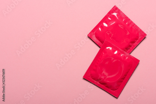 Fotografía Two condoms in closed foil packaging on pink pastel background with copy-space
