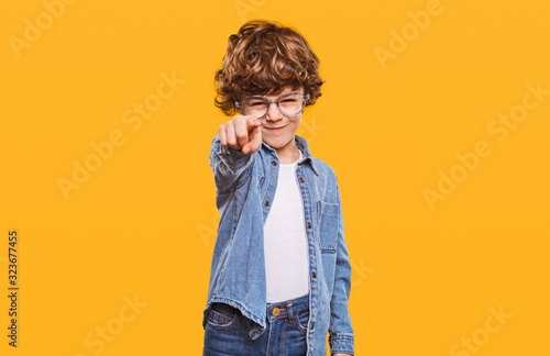Stylish kid pointing with forefinger at camera photo