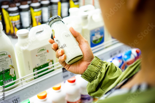 BANGKOK THAILAND - January 12, 2020: Woman's hand buying milk in the supermarket. Woman choosing milk in dairy product department.