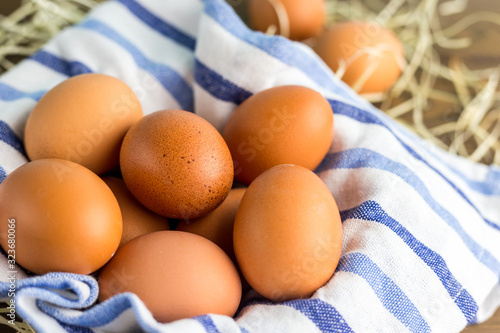 Brown Chicken eggs with cloth on the wooden table. Farm natural products, food or Easter concept