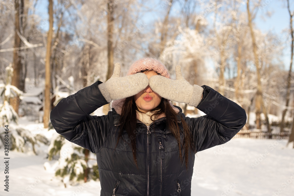 woman covering her eyes in winter park woman covering her eyes in winter park