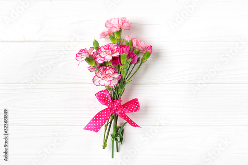 Fototapeta Naklejka Na Ścianę i Meble -  bouquet of different pink carnation flowers on white wooden background Top view Flat lay Holiday card 8 March, Happy Valentine's day, Mother's day concept