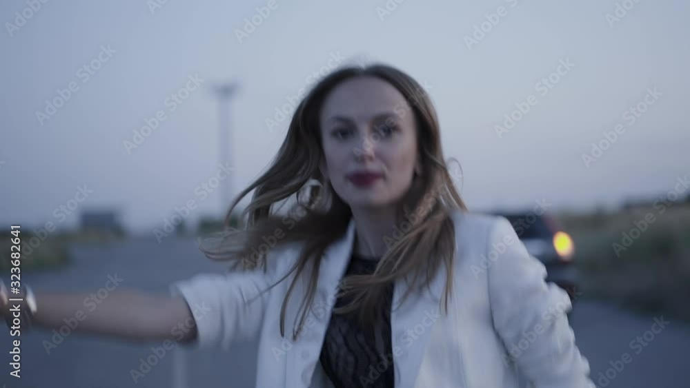 Portrait of sad girl tries to stop passing cars on roadway out of city Portrait of sad girl tries to stop passing cars on roadway out of city