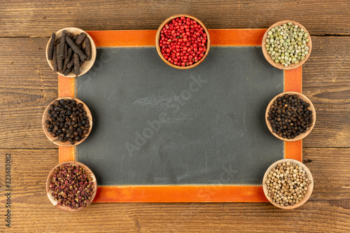 фотографія Sven small wooden bowls filled with different kinds of pepper and an old black s