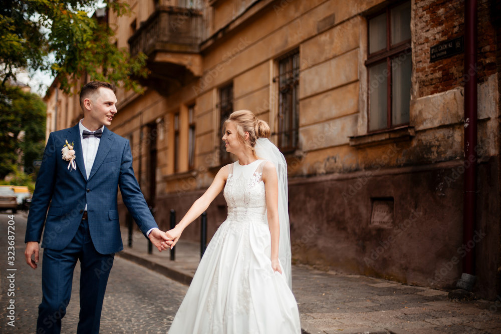 A loving couple of newlyweds walks in the city. Husband and wife on a walk A loving couple of newlyweds walks in the city. Husband and wife on a walk