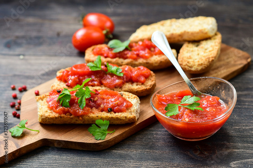 Fotografía Italian bruschetta with tomatoes, olive oil, green parsley and pink pepper