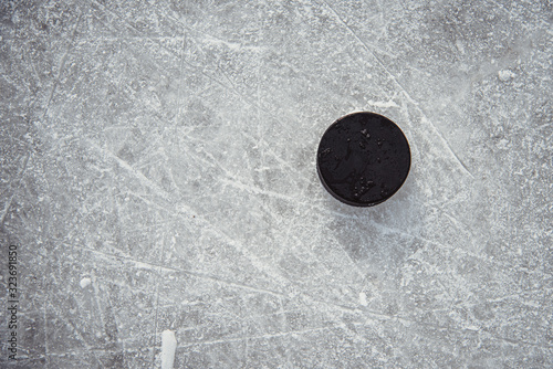 Photography hockey puck lies on the snow close-up