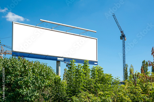 Huge blank white billboard for advertisement near construction site photo