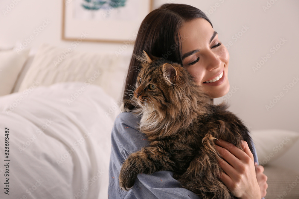 Beautiful young woman with her cute cat in bedroom. Fluffy pet Beautiful young woman with her cute cat in bedroom. Fluffy pet