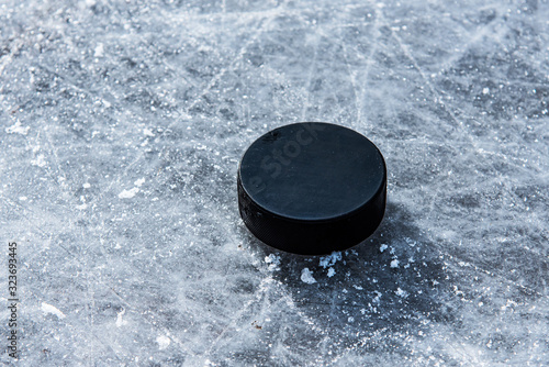 Canvas Print hockey puck lies on the snow close-up
