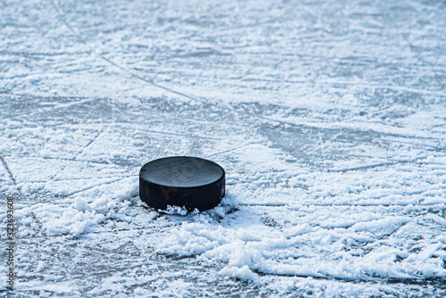 Canvas Print hockey puck lies on the snow close-up