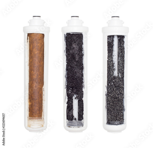 Used water cartridges in section on a white background. The concept of water purification from heavy metals, rust and toxic substances, isolate, natural photo