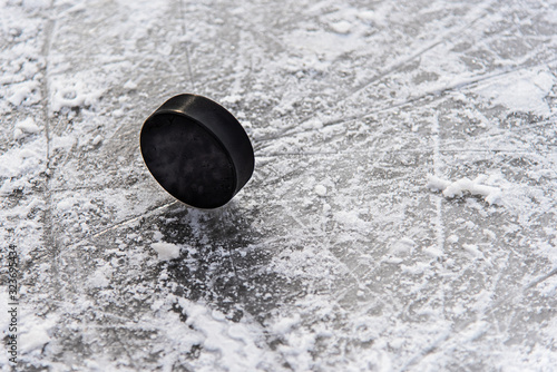 Canvas Print hockey puck lies on the snow close-up
