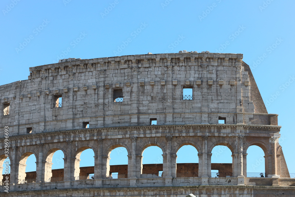 detail of the ancient Colosseum perimeter walls in Rome with blue sky