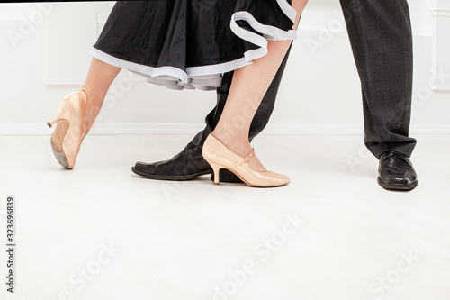 Partner dance. Male and female ballroom, standard, sport dance, latin and salsa couple dancers feet and shoes in dance rehearsal room dancing salsa.