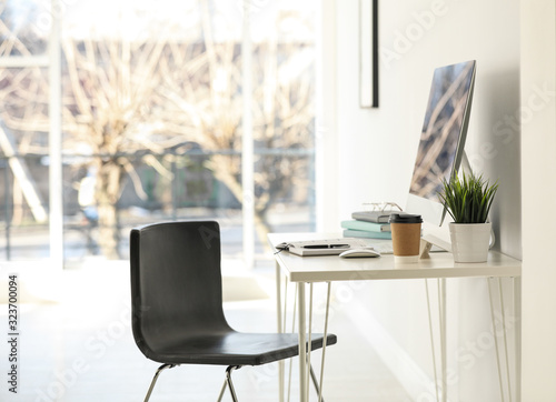 Computer, notebooks and coffee on table in office