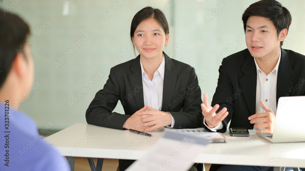 Male and female university student team are presenting a project to request research funding from businessmen. Male and female university student team are presenting a project to request research funding from businessmen.