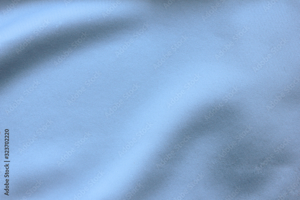Fototapeta premium Silky blue sheet material, empty fabric texture wrinkled pattern. Crumpled cloth surface, bluish white background mockup, close up top view 