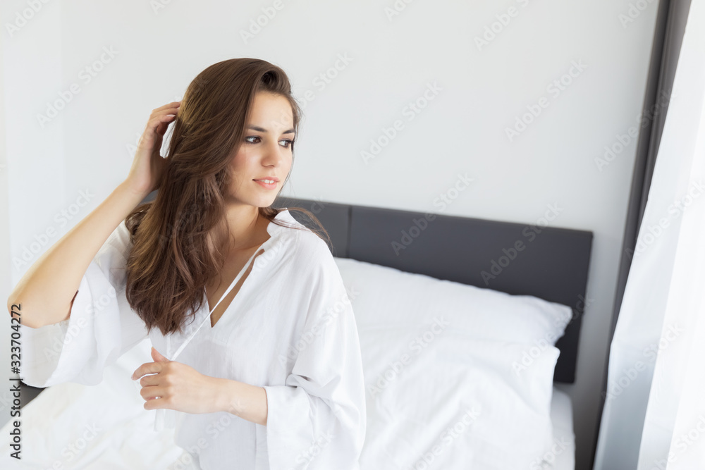 Woman enjoying morning awakening in a soft snow-white bed. Woman enjoying morning awakening in a soft snow-white bed.