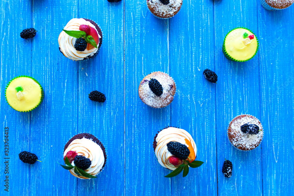 Freshly baked sweet muffins on a blue background. Sweet pastries, recipes, cooking Freshly baked sweet muffins on a blue background. Sweet pastries, recipes, cooking