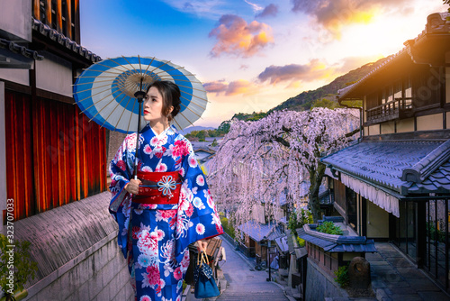 Young women in beautiful Japanese kimono dress enjoying Historic Higashiyama district, Kyoto in Japan. photo