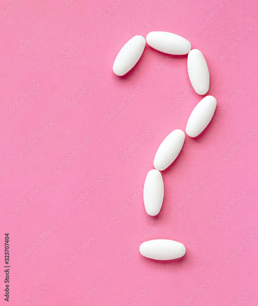 Question mark white pills on pink background. Medicine science. Cure concept Question mark white pills on pink background. Medicine science. Cure concept