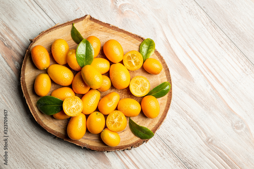 Pile of kumquat fruits, chinese tangerines, on wooden cutting board. Pile of kumquat fruits, chinese tangerines, on wooden cutting board.