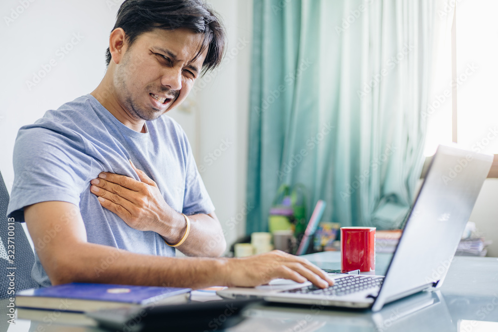 Young Asian office worker having chest pain , Overworked concept , office syndrome Young Asian office worker having chest pain , Overworked concept , office syndrome