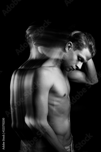 pensive man touches his head. sexy naked torso black and white portrait. long exposure creative Technic. looking side. 