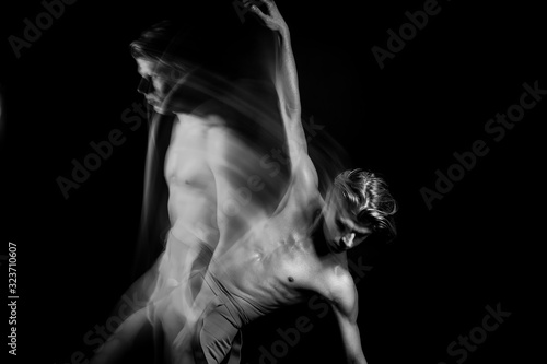 athletic Dancing creative long exposure naked torso man. Fit body. graceful and exciting hand up. Black and white series of long exposure creative photo series. Emotional abstract inspiration