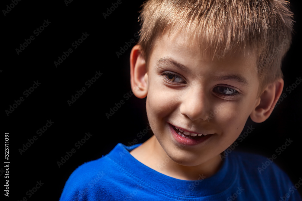 Portrait of the boy 's smiling child close-up against a black background Portrait of the boy 's smiling child close-up against a black background