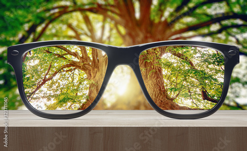 Vision concept. Eye glasses on wooden table. 3d rendering