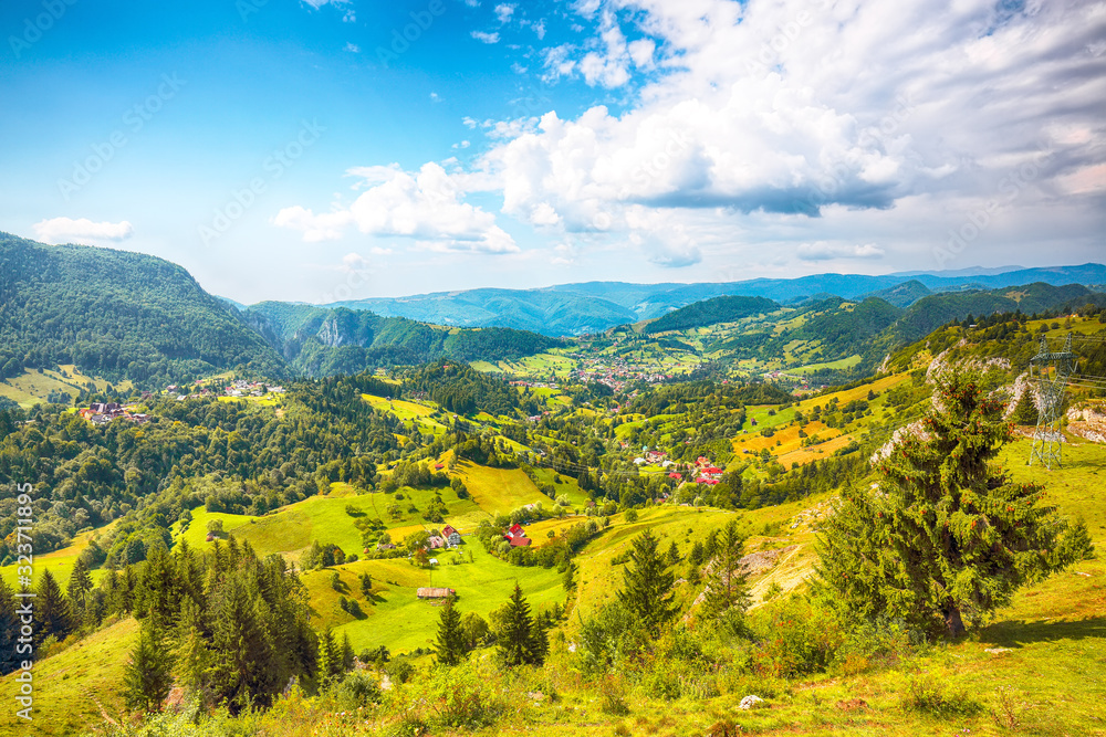 Stunning alpine landscape with green fields and Piatra Craiului mountains in Dambovicioara Commune