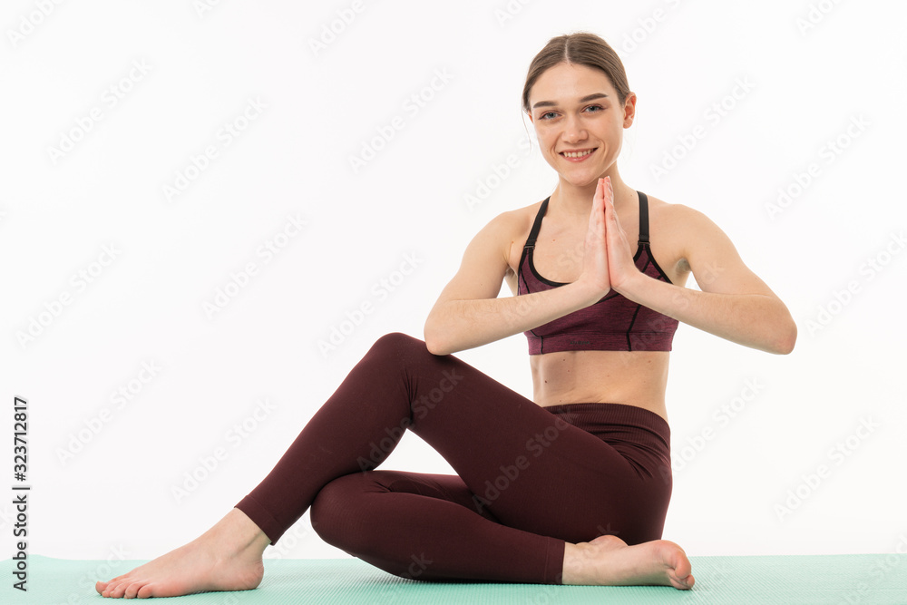 Sporty young woman doing yoga practice isolated on white background. Concept of healthy life and natural balance between body and mental development. Sporty young woman doing yoga practice isolated on white background. Concept of healthy life and natural balance between body and mental development.